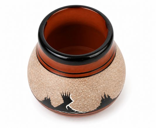 A small round ceramic pot with a textured beige exterior, a glossy reddish-brown interior and rim, and black decorative silhouettes near the base, shown on a white background.