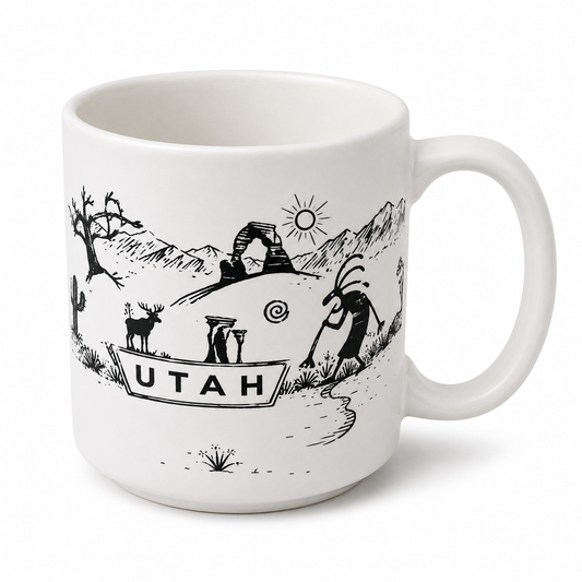 A white ceramic mug featuring a black line art illustration of Utah landmarks, including Delicate Arch, a deer, a cactus, and the word 'UTAH' on a boat.
