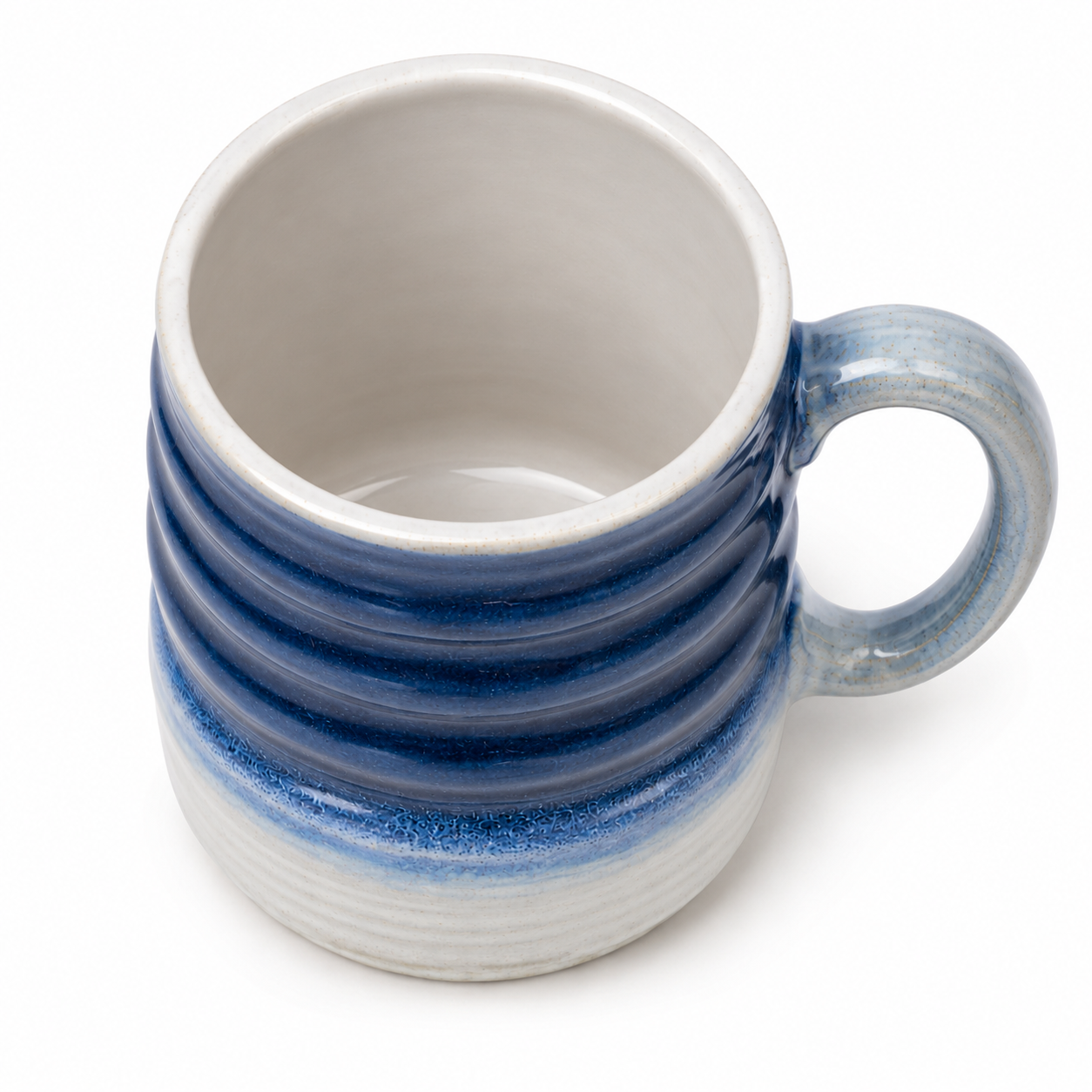 A ceramic mug with a ribbed exterior featuring a blue and gray gradient glaze, and a smooth off-white interior, shown on a white background.