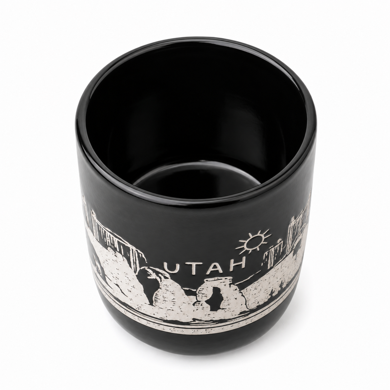 A black ceramic tumbler with a white printed graphic of the Utah state skyline, including the word 'UTAH' and a sun, shown on a white background.